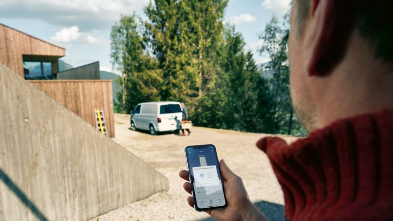 En man fjärrstyr funktioner i sin VW Transporter med We Connect i mobilen