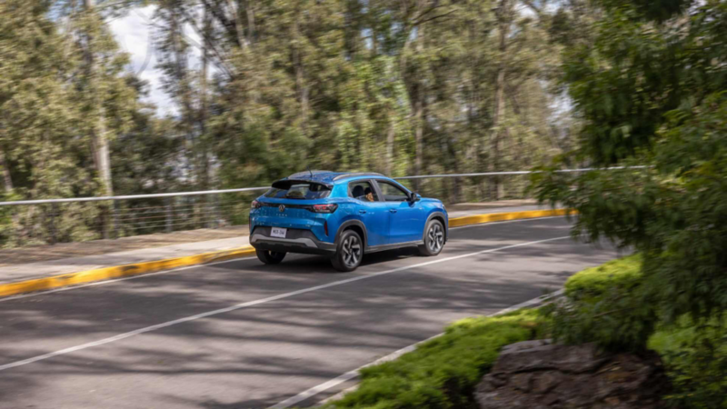 Volkswagen Tera azul circula por carretera arbolada.