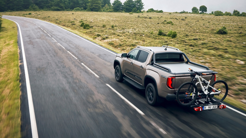 Volkswagen Amarok z bagażnikiem rowerowym jedzie po trasie.