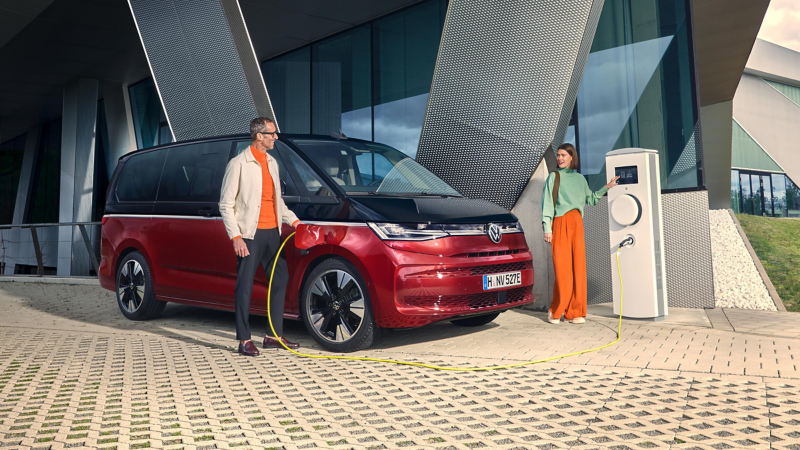 A couple charges the VW Multivan at a charging station.