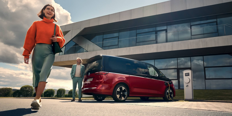 The new VW Multivan stands at a charging point and is being charged.