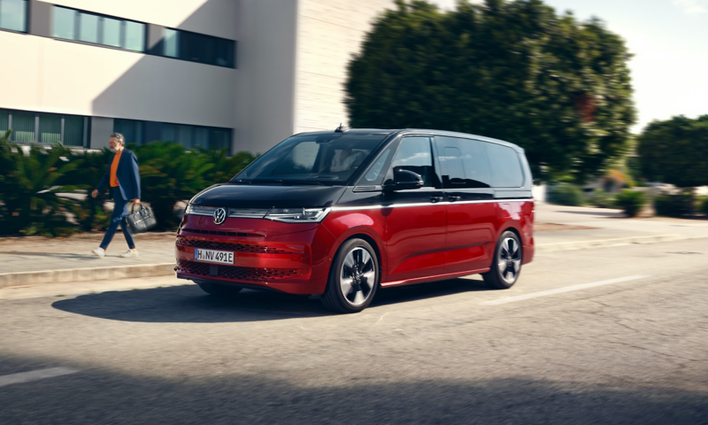 Exteriören på en röd-svart VW Multivan minibuss.