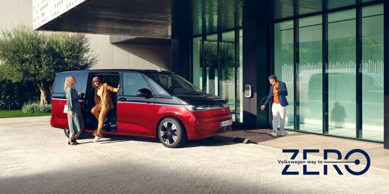 VW Multivan Style eHybrid vid en laddbox med loggan Volkswagen Way to Zero