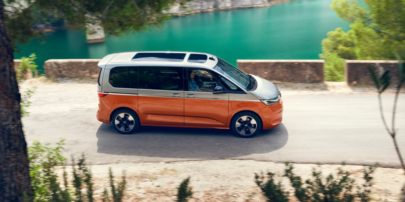 A VW Energetic drives along a lake road.