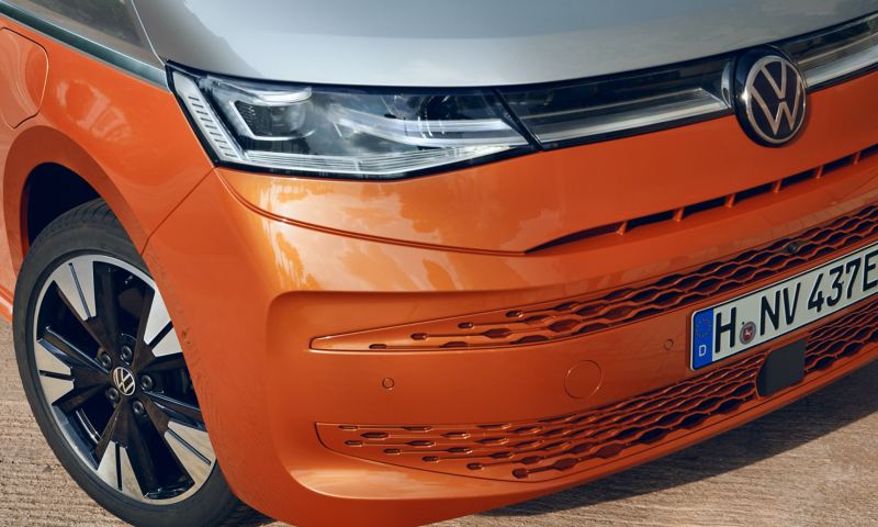 Fronten på en orange VW Multivan eHybrid visar IQ. Light strålkastare i närbild.