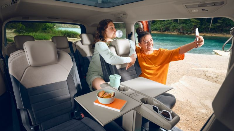 Zwei Mädchen machen ein Selfie im Inneraum des VW Multivan.