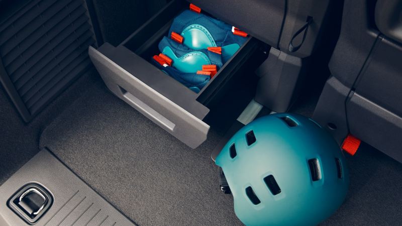 The storage drawers under the seats in the VW Multivan.