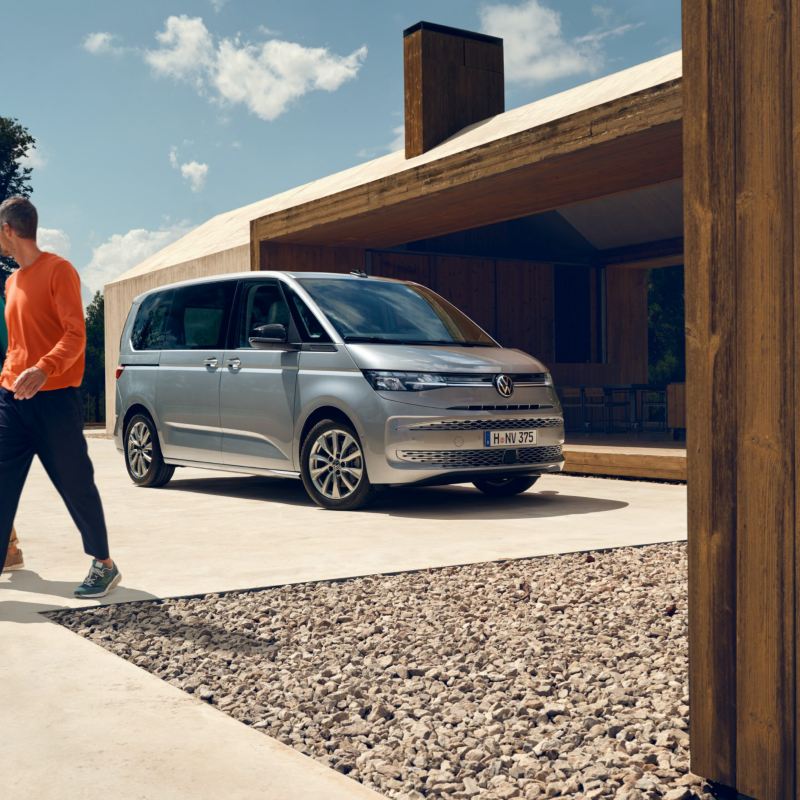 Zwei Männer entfernen sich von einem parkenden VW Multivan Life.