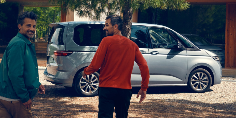 Deux hommes courent en direction d’un Multivan Life garé.