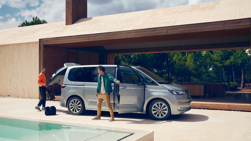En VW Multivan minibuss står parkerad vid en pool