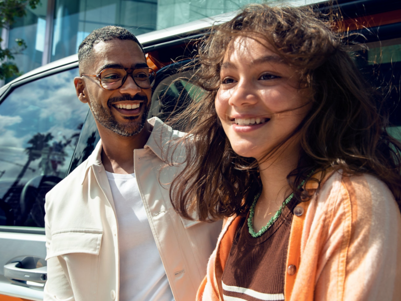 Ein Pärchen steht vor einem Volkswagen.