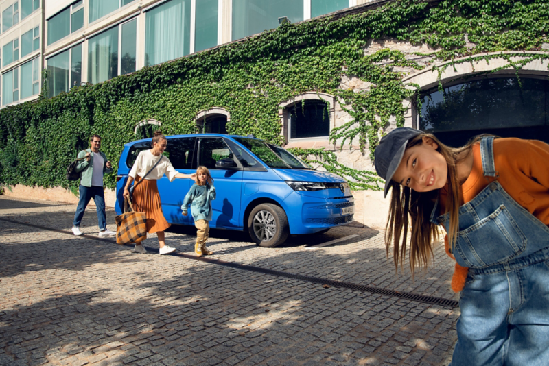 Rodzina na tle niebieskiego VW Multivana Family