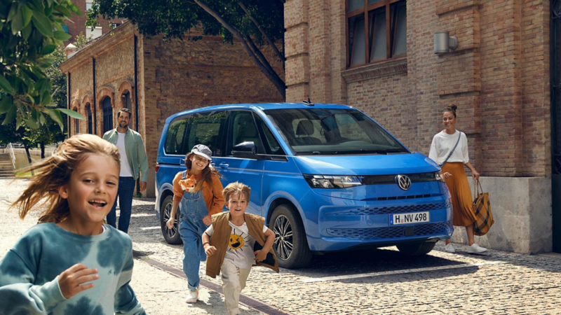 En familj går framför sin förmånsbil, en blå VW Multivan