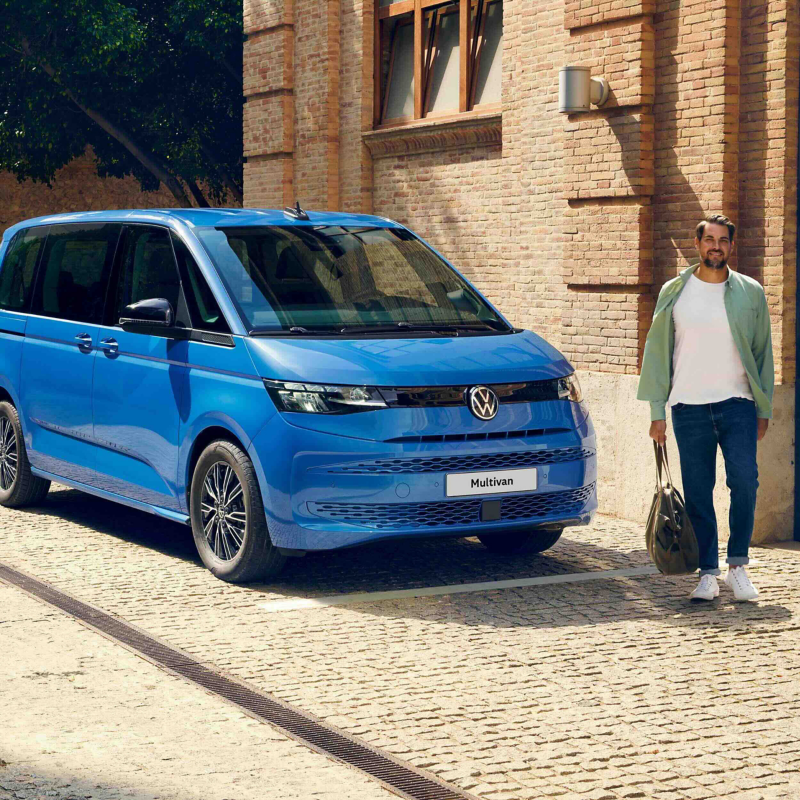 person walking next to a new volkswagen multivan