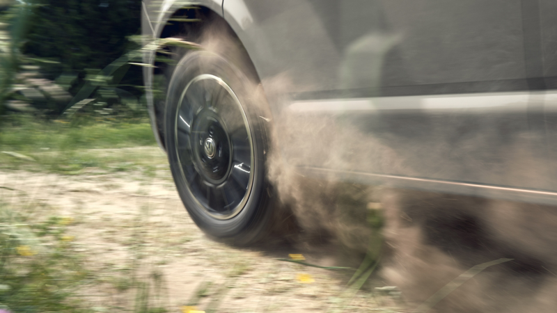 Zoom sulla ruota di un veicolo commerciale VW in movimento su strada sterrata.