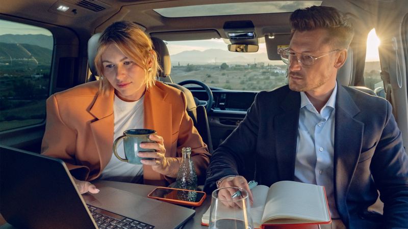 Zwei Journalisten sitzen in einem VW Multivan.