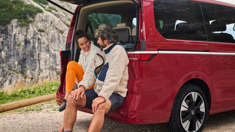Man och kvinna sitter i bagaget på en VW Multivan