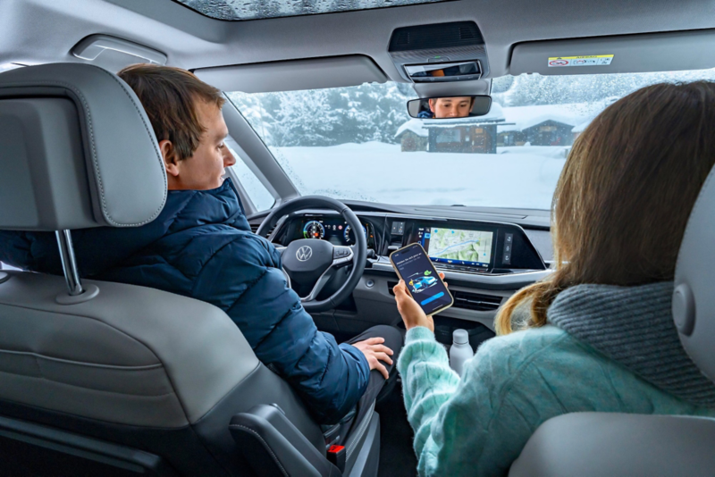 El VW Nuevo California aparcado en la orilla junto a dos personas.