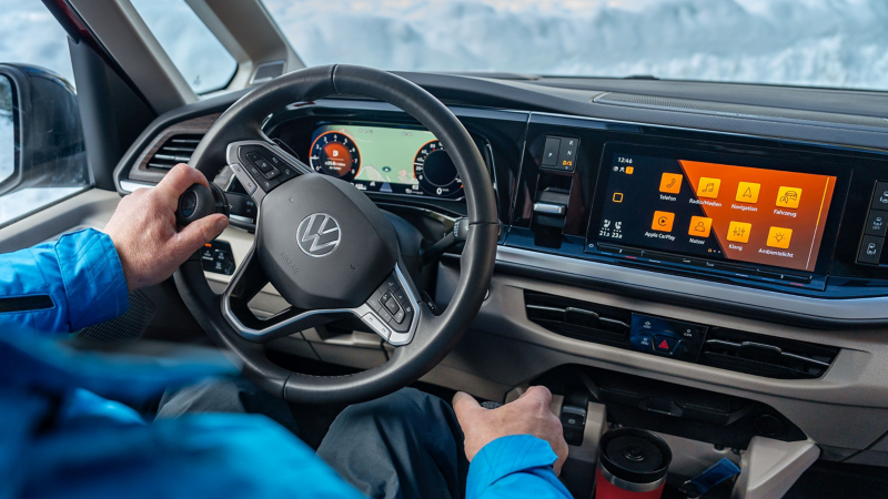 Eine Person am Steuer eines VW Multivan.