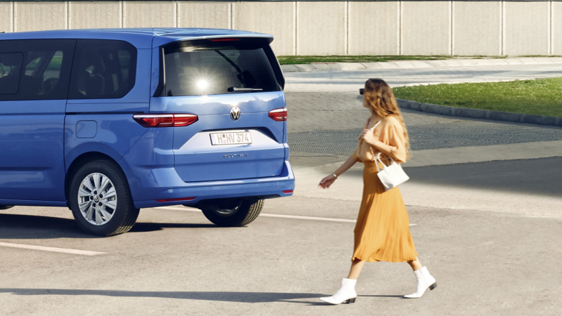 El VW Nuevo California aparcado en la orilla junto a dos personas.