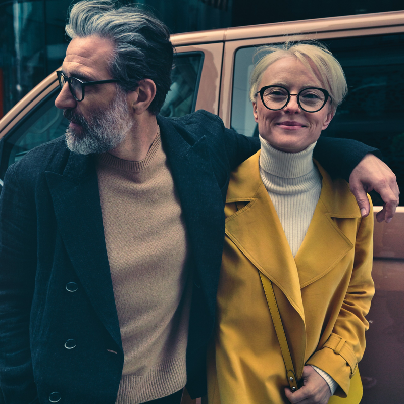 Ein Mann und eine Frau stehen Arm in Arm vor einem Volkswagen.