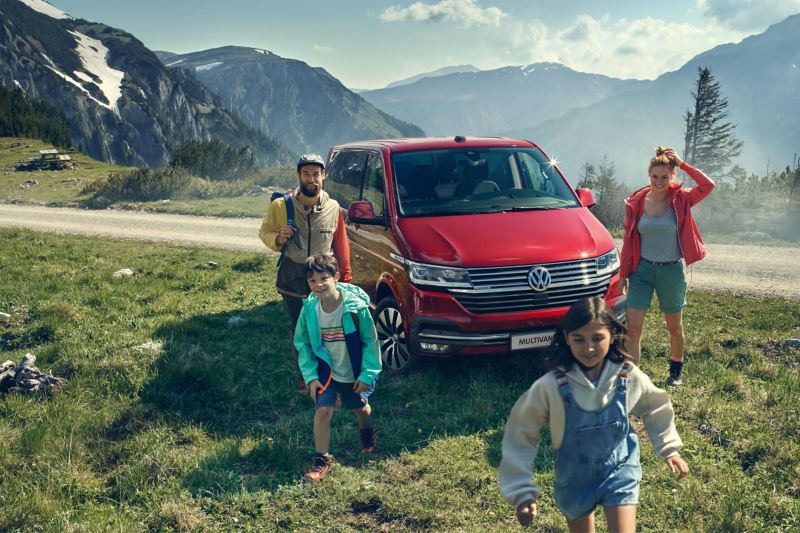 Rodzina obok czerwonego Volkswagen Multivan 6.1.