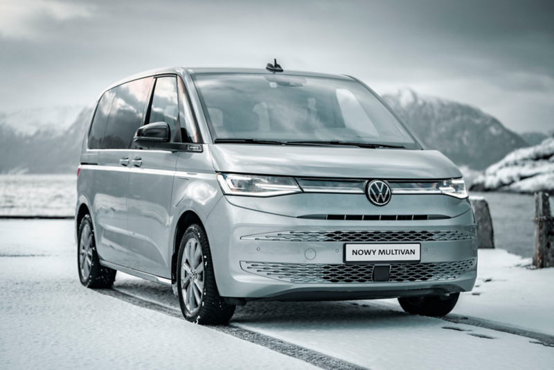 Volkswagen Multivan stoi na śniegu, na tle gór.