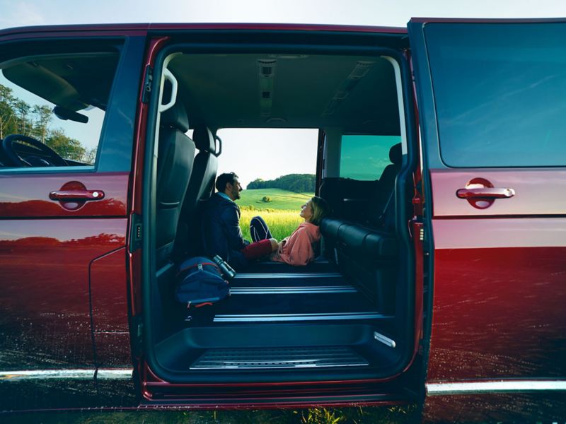 Couples talking to each other inside the Volkswagen Multivan With sliding doors opened