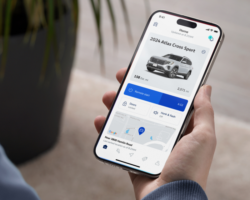Persona sosteniendo un dispositivo móvil, usando la aplicación myVW.