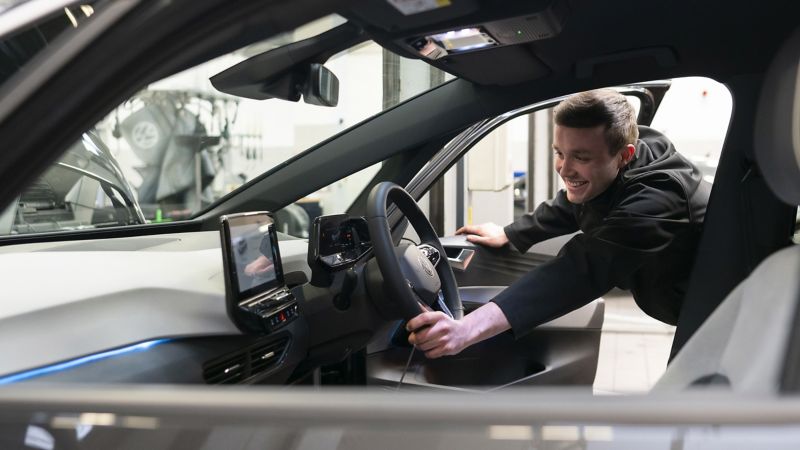 A VW mechanic inspecting the inside cockpit of a VW ID.3