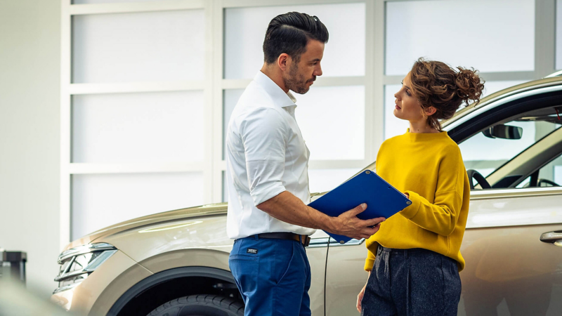 A customer talking to a VW employee in a showroom