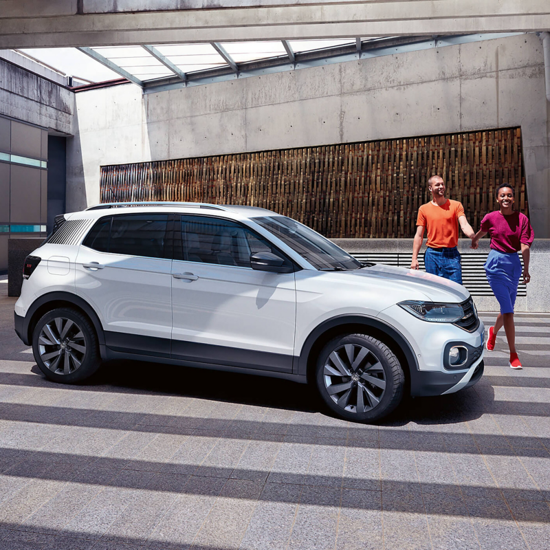 Couple standing outside by their car