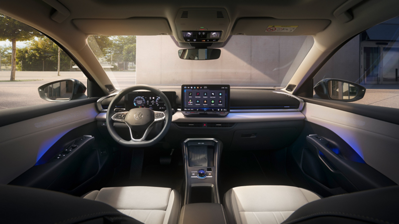 Blick in den Innenraum eines VW T-Roc vom Rücksitz aus, sichtbar sind Lenkrad, digitales Cockpit, Mittelkonsole und das grosse zentrale Display.