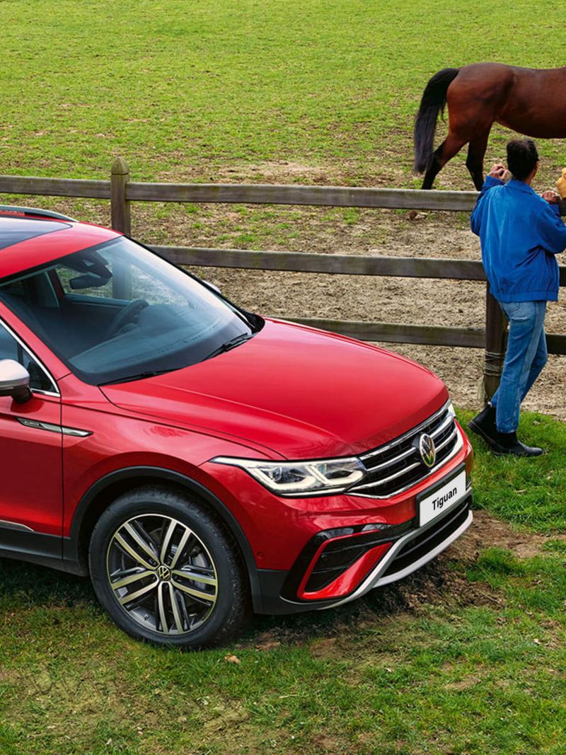 red tiguan allspace parked in a field