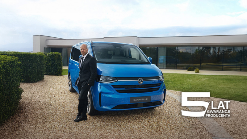 Jason Statham stoi oparty o Volkswagena Caravelle.