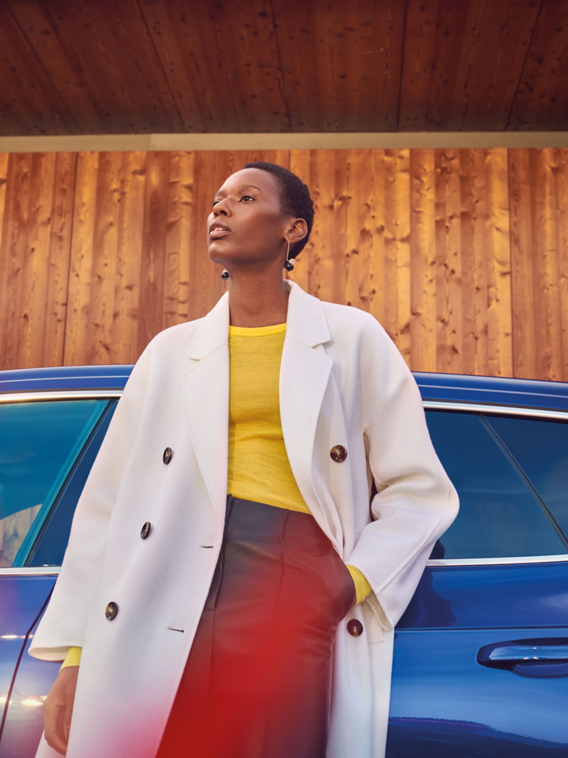 A woman leans against her VW R Arteon R Shooting Brake