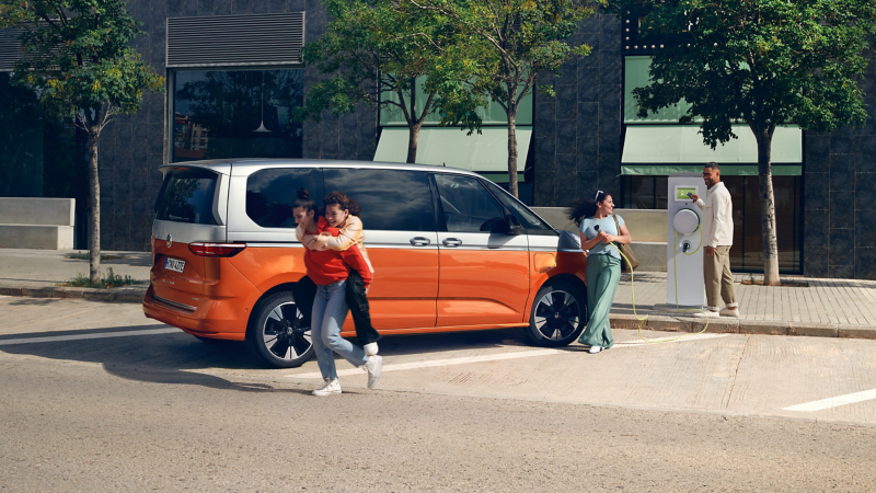 Une VW Multivan est stationnée à une borne de recharge publique.