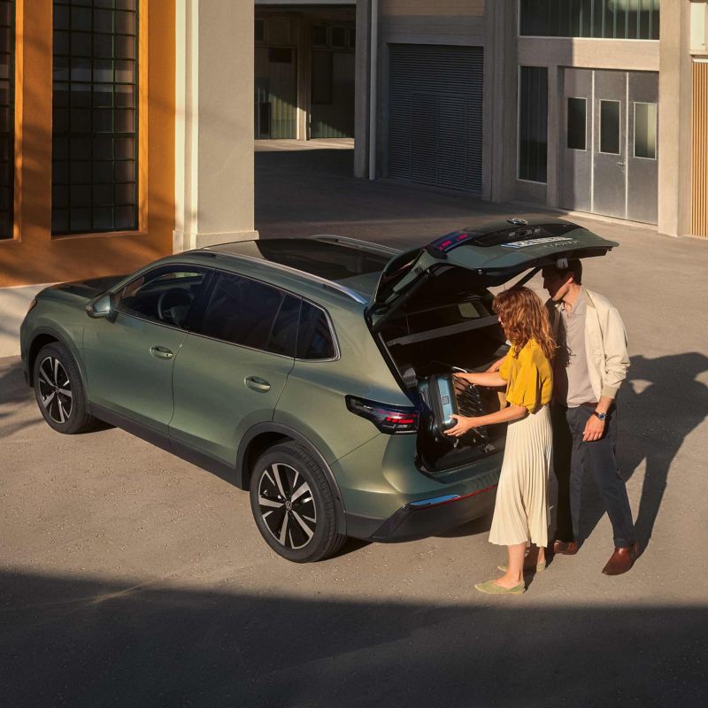 A couple loading bags into the booth of a VW Tiguan