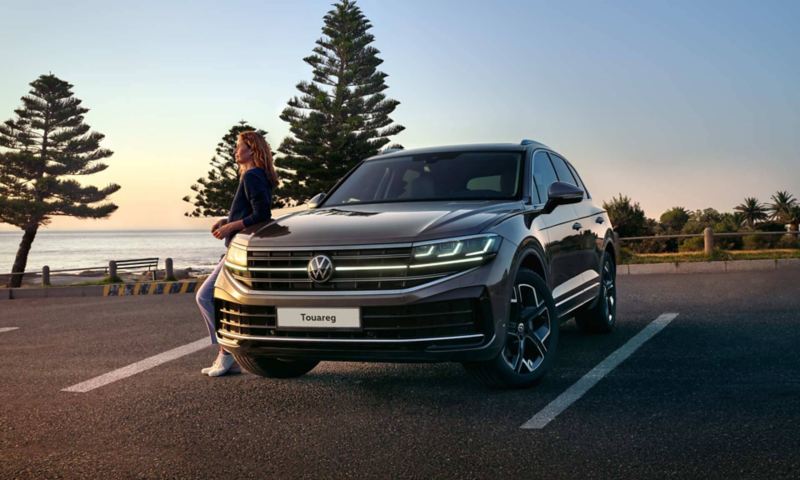 A VW Touareg Elegance at dusk by the sea with the HD matrix headlights switched on. 