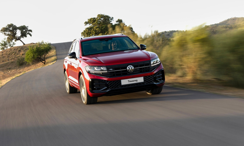 A red Volkswagen Touareg driving in the countryside