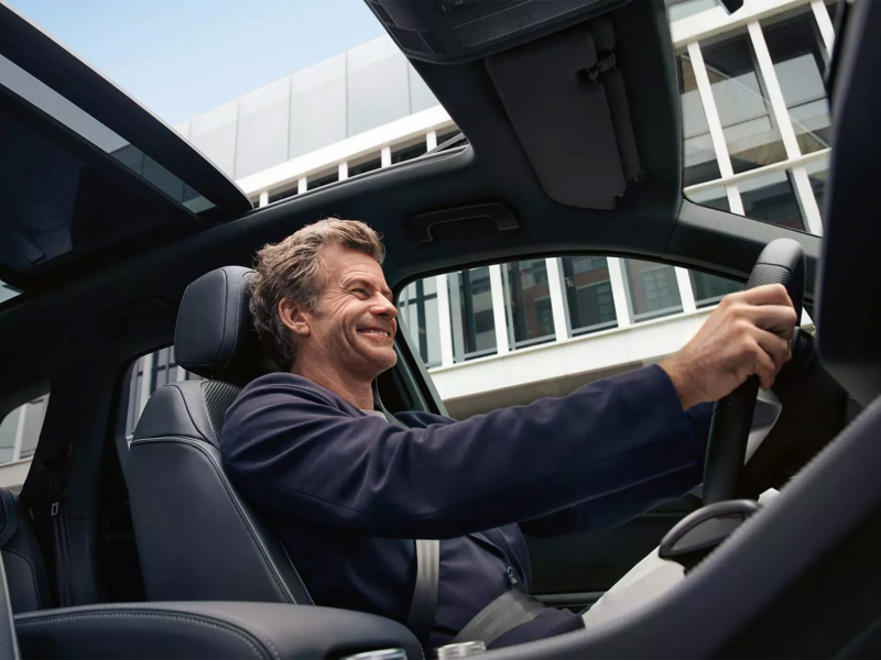 Man sat in car holding steering wheel
