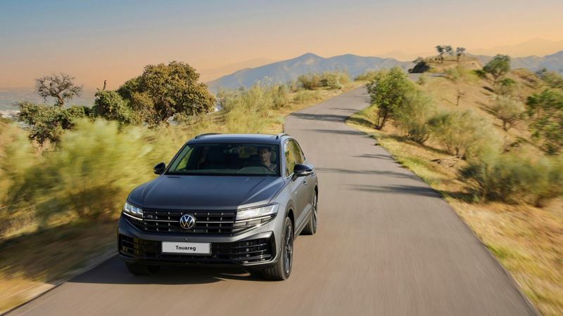 View of the Touareg R eHybrid from the front driving down a mountain road