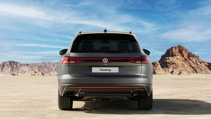 View of the Touareg R eHybrid from the back parked infront of a mountain view