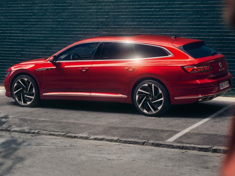 A red all new Arteon Shooting Brake parked in front of a building