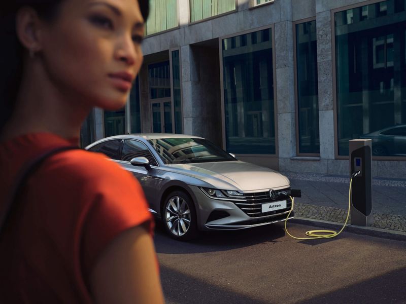 Arteon is connected to a charging station with cables from the hood