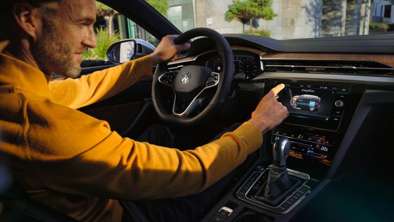 Man sits in the interior of the Arteon Shooting Brake and operates the touch display