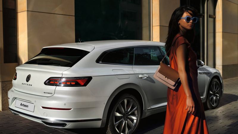 A woman standing by a parked Arteon Shooting Brake