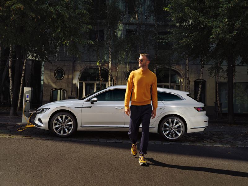 A man charging his Arteon Shooting Brake at the side of the road