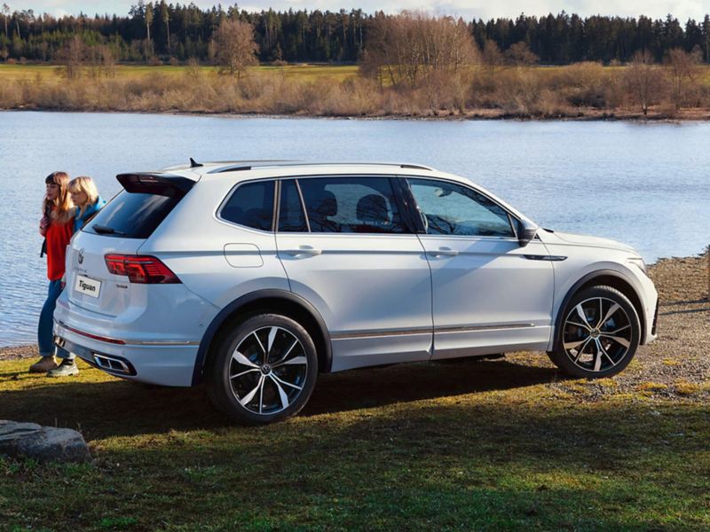 A white VW Tiguan parked on a river bank