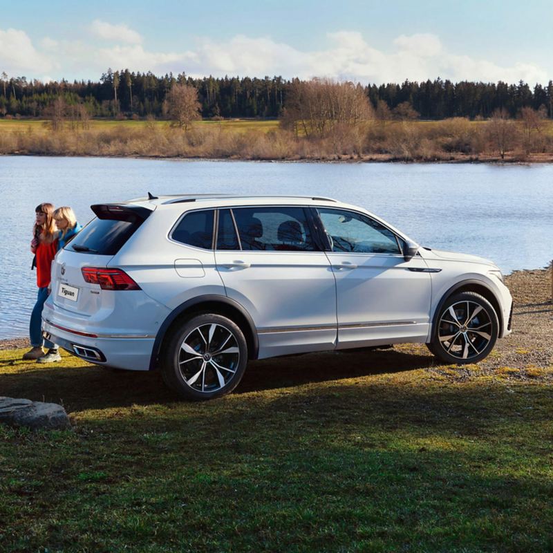 A white VW Tiguan parked on a river bank